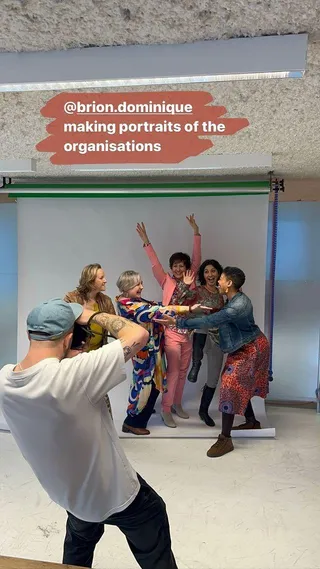 A photographer directing a group portrait of an organisation